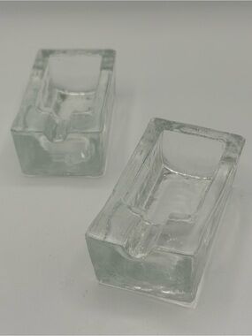 A pair of clear glass 'ice block' design individual ashtrays, etched 'Italy'.